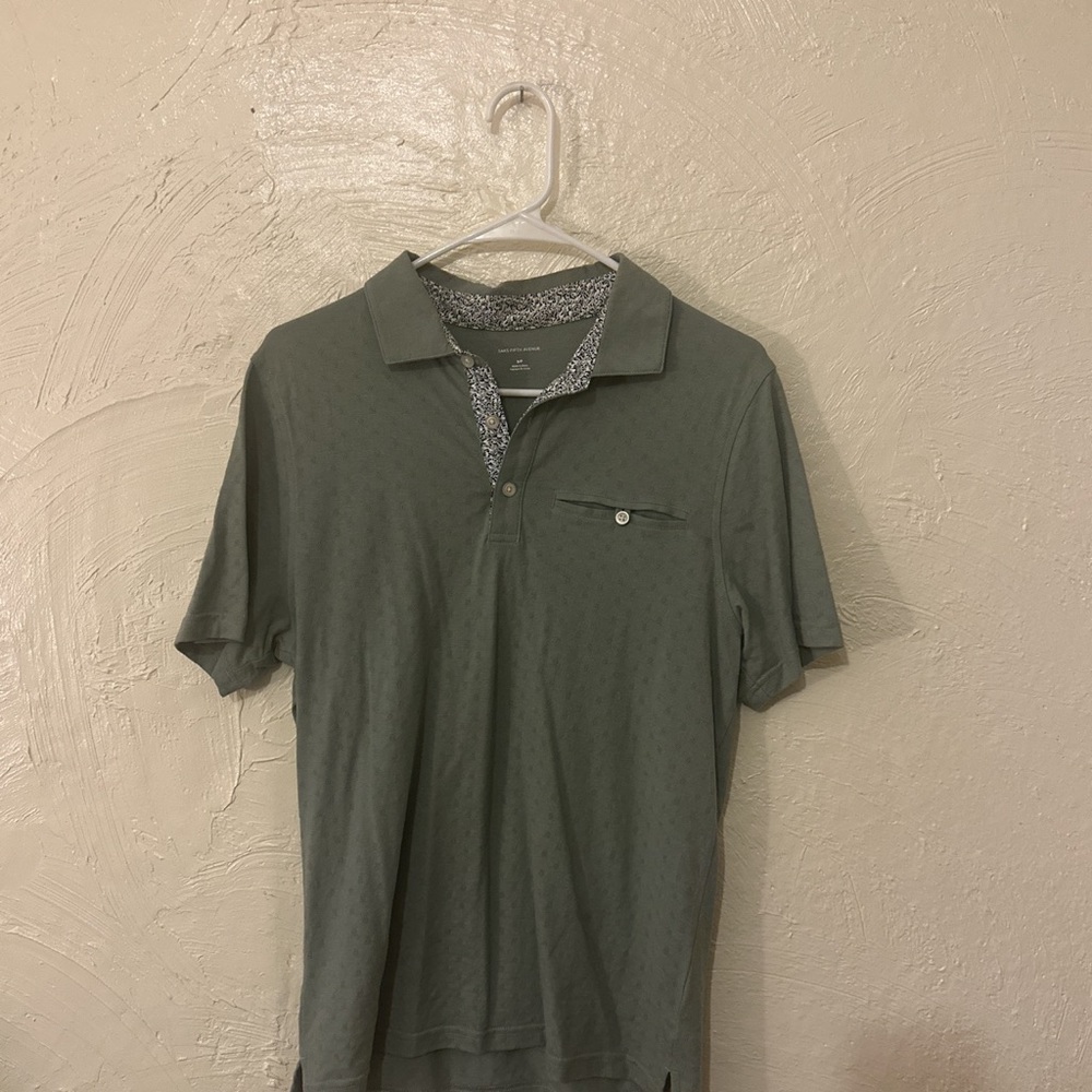 green Saks polo with white and blue floral pattern around neck and collar